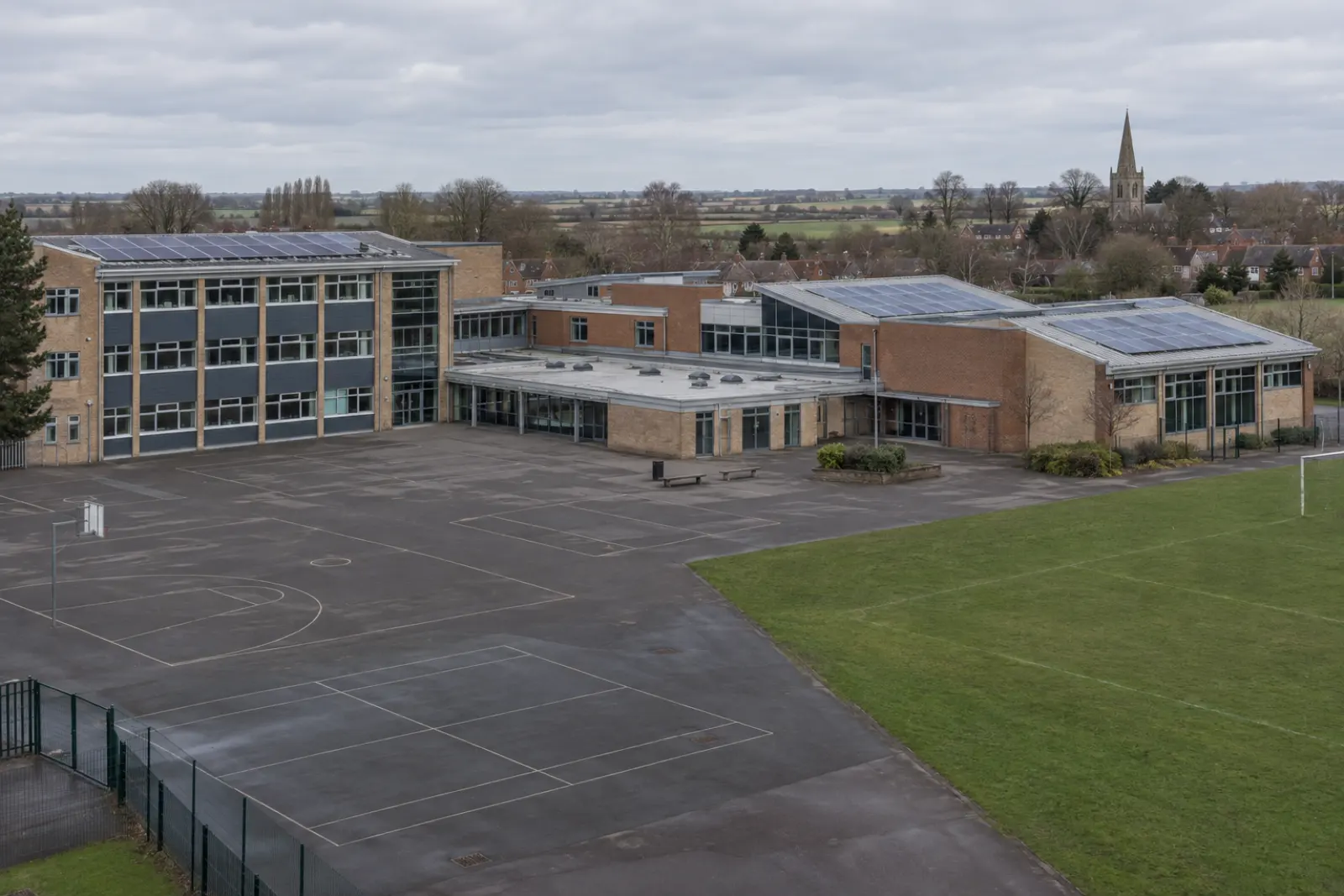A school on the edge of a Midlands town, solar arrays on its roofs and flat open farmland beyond