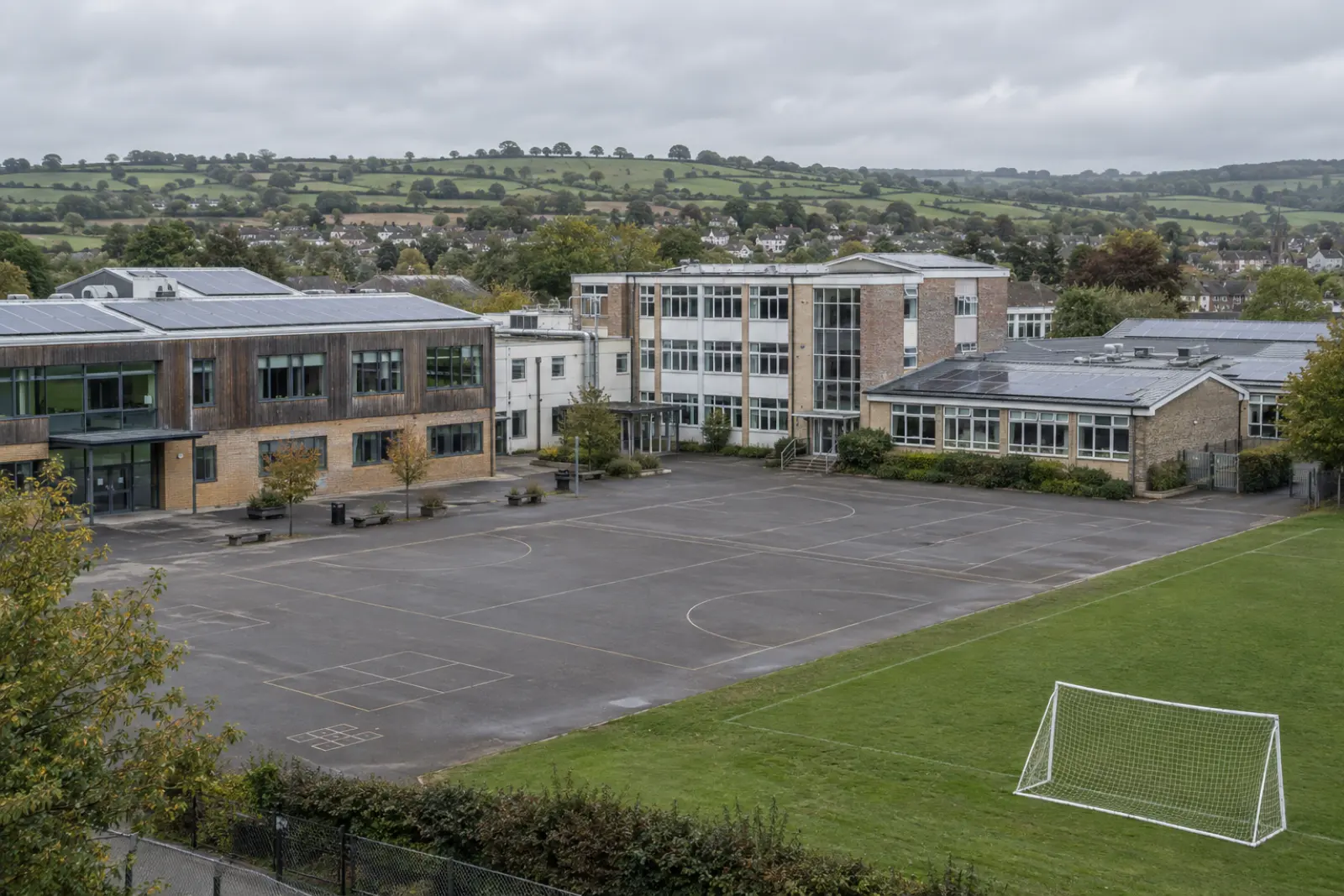 A school on the edge of a South West market town, solar arrays on its roofs and rolling farmland beyond